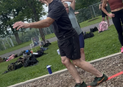 Participant adulte en équilibre sur slackline lors d’un atelier de team building axé sur la motricité et la concentration.